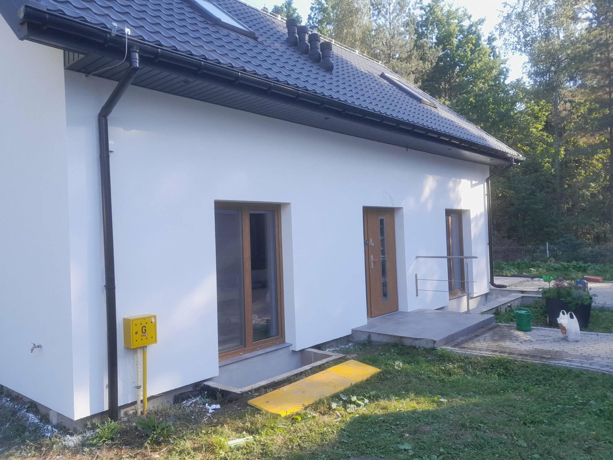 Wykończona elewacja domu jednorodzinnego z wejściem