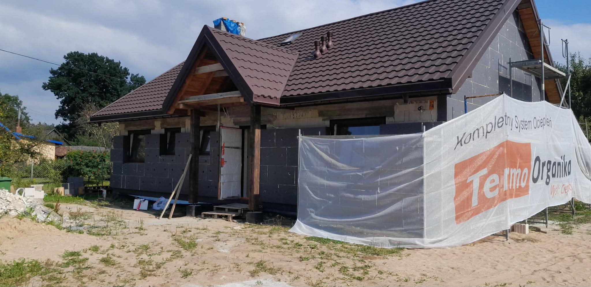 Dom w trakcie ocieplenia – płyty styropianowe na elewacji i rusztowanie